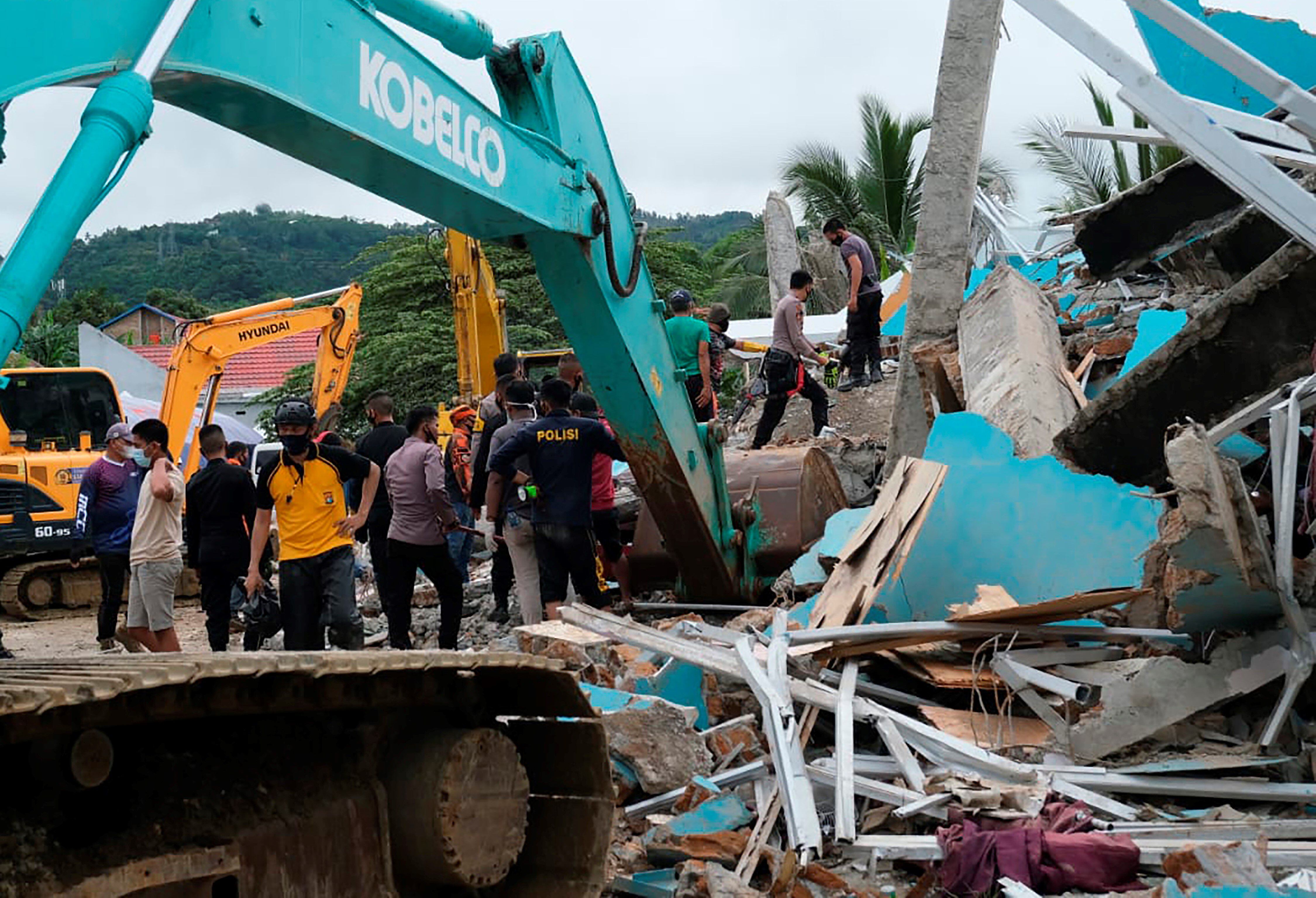 Rescatistas   buscan sobrevivientes en las ruinas de un edificio del gobierno local que colapsó durante un terremoto en Mamuju, West Sulawesi, Indonesia