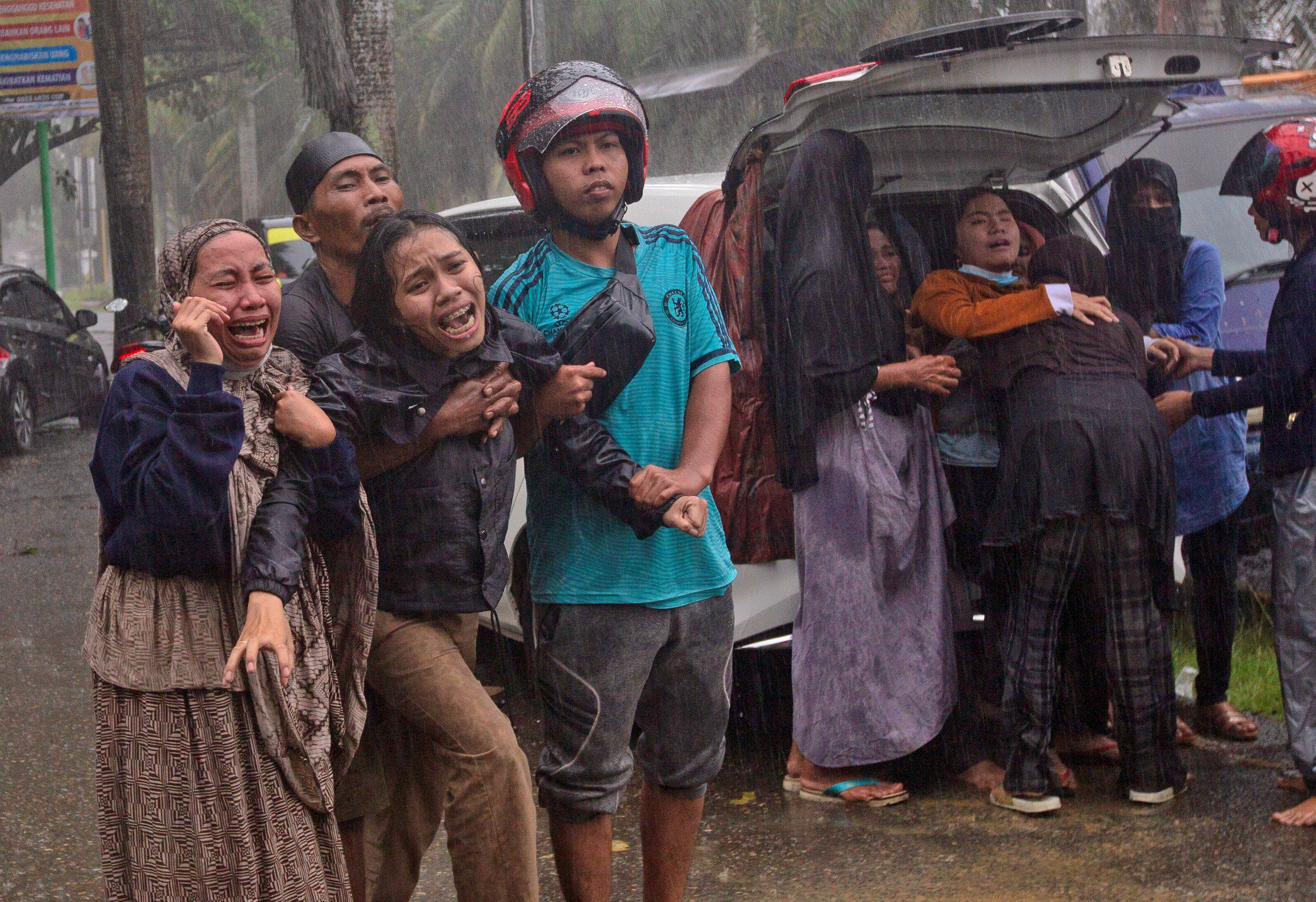 La   gente reacciona cuando el cuerpo de un familiar es recuperado de las ruinas de un edificio en un área afectada por un terremoto en Mamuju, West Sulawesi, Indonesia