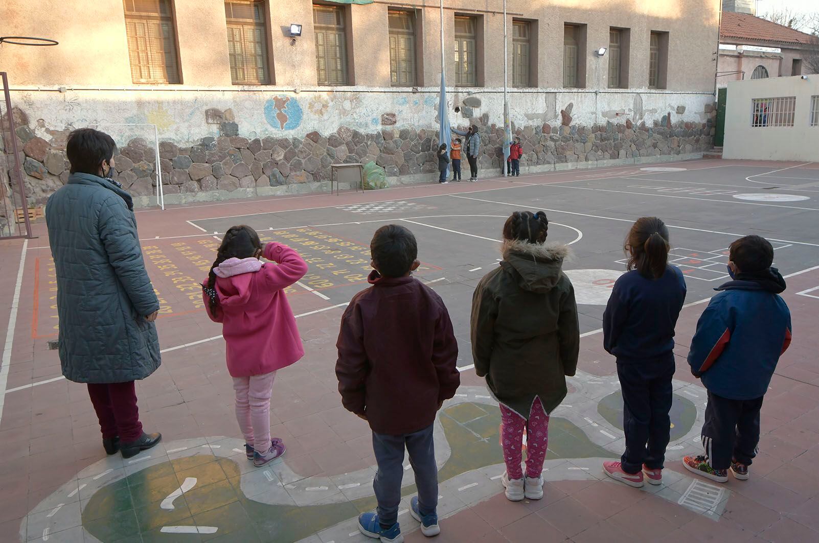 Alumnos izan la bandera en la Escuela Carmen Ponce de Videla en el regreso a clases presenciales en Mendoza. 